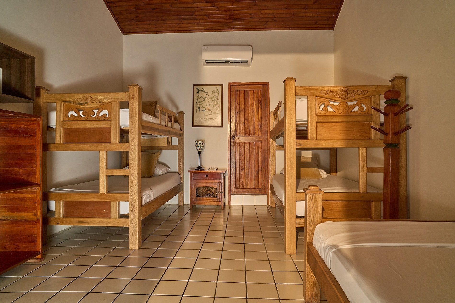 a room with three bunk beds and a dresser