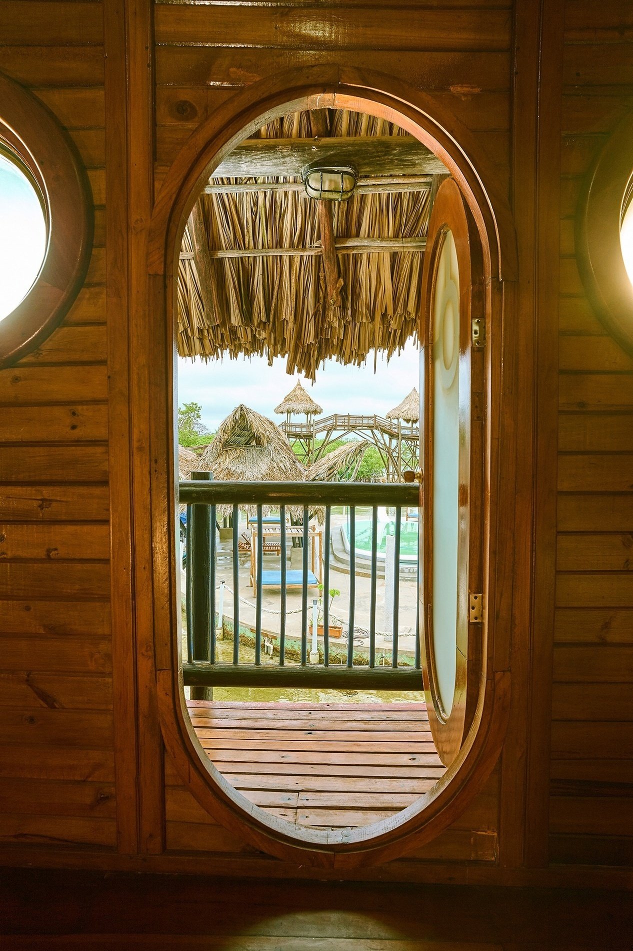 a round window in a wooden building looking out to a balcony