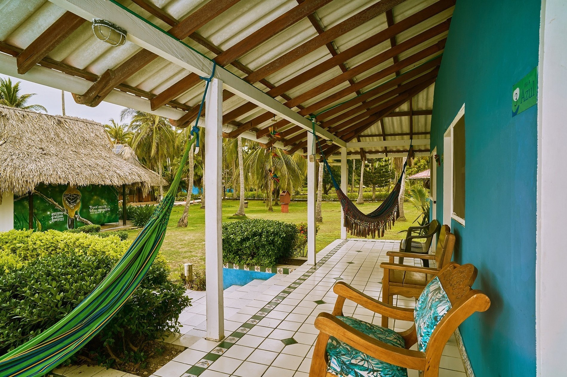 a hammock hangs from the roof of a porch