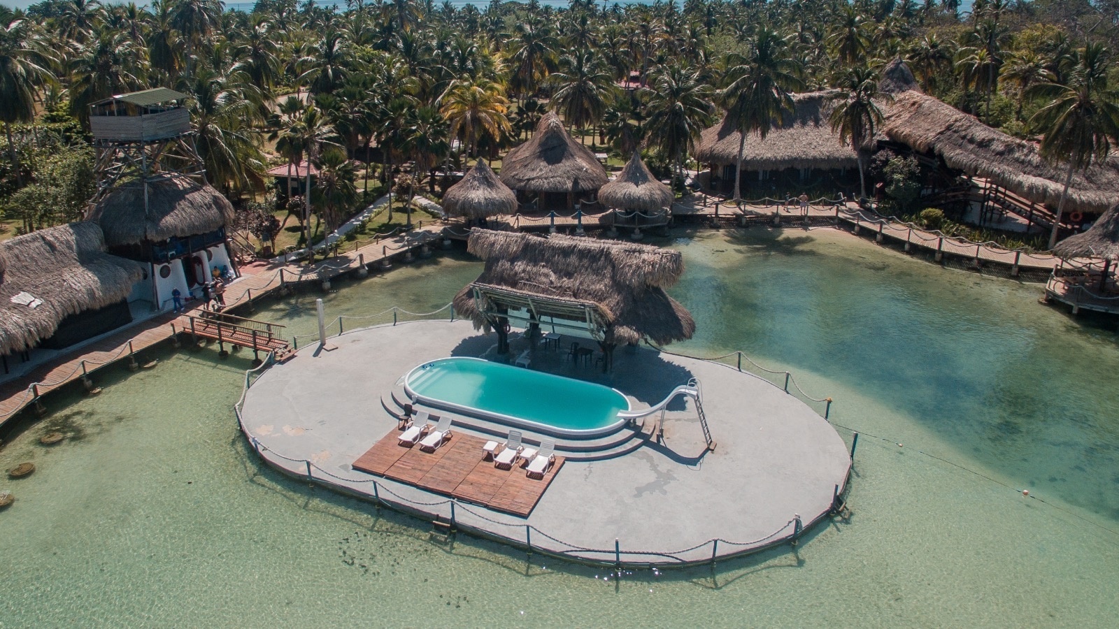 an aerial view of a swimming pool in the middle of the ocean