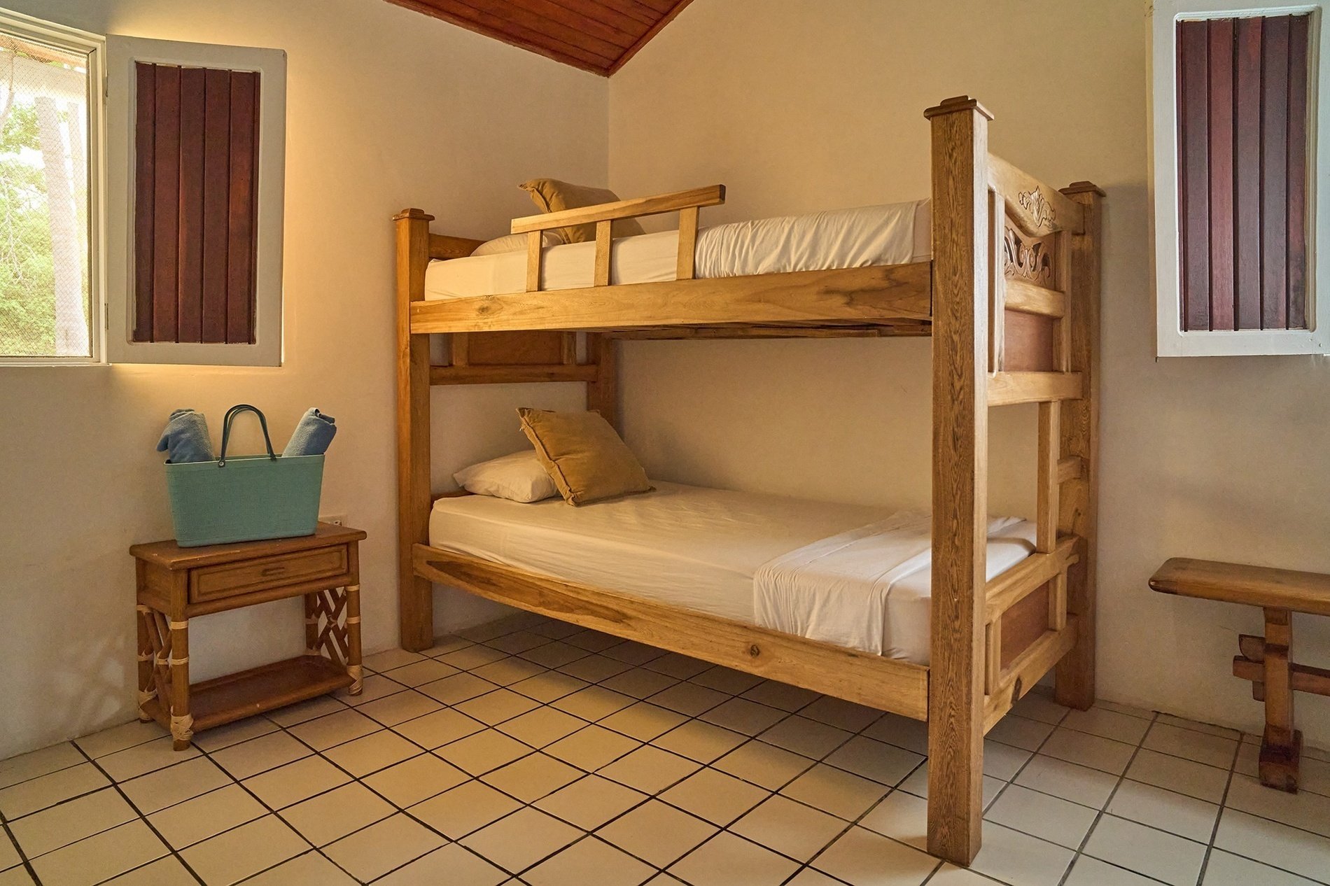 a bunk bed in a room with a blue bag on a nightstand