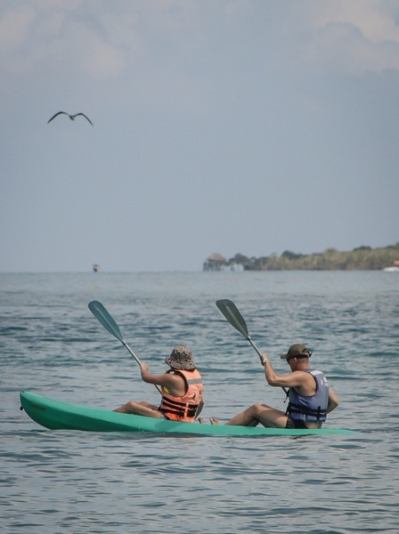 a man and a woman are paddling kayaks in the ocean