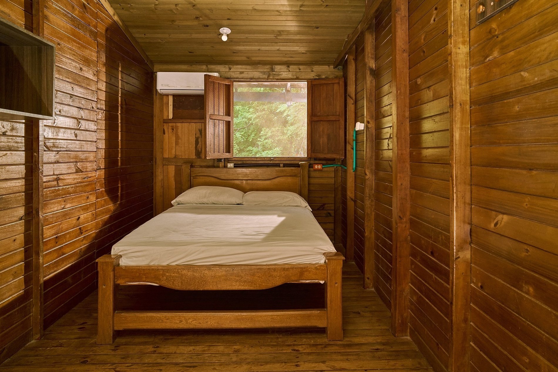 una habitación de madera con una cama y una ventana