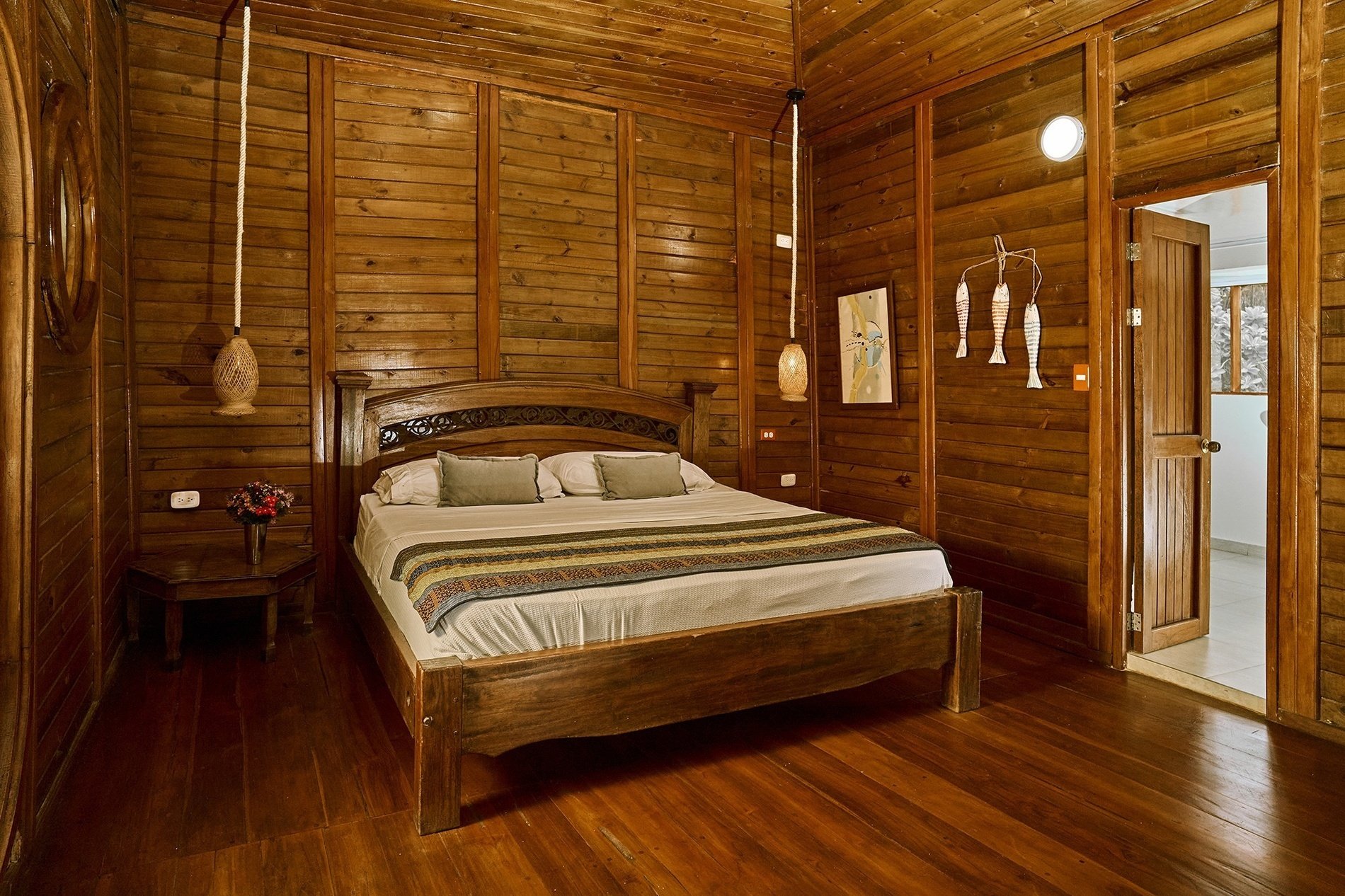 una habitación de madera con una cama y una mesa de noche