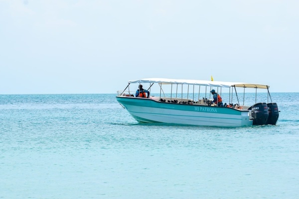 un barco en el océano con un muelle en el fondo