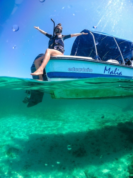 una mujer se sienta en el costado de un barco que lleva el nombre de eduardiño malia