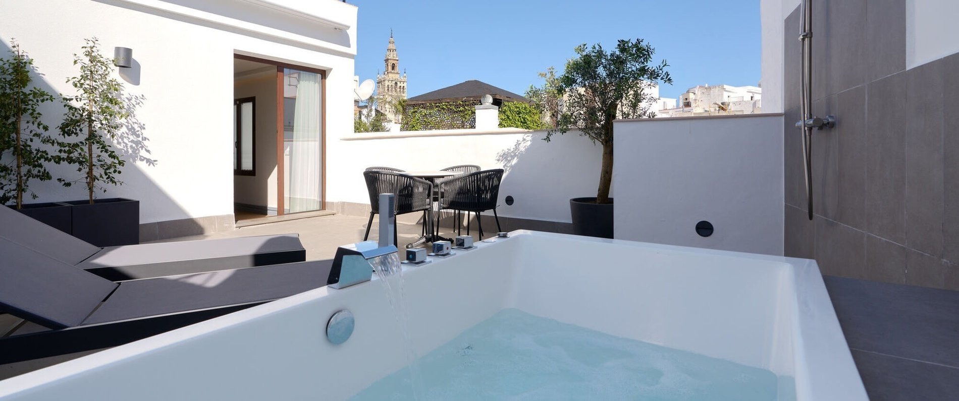 a bathtub on a balcony with a tower in the background