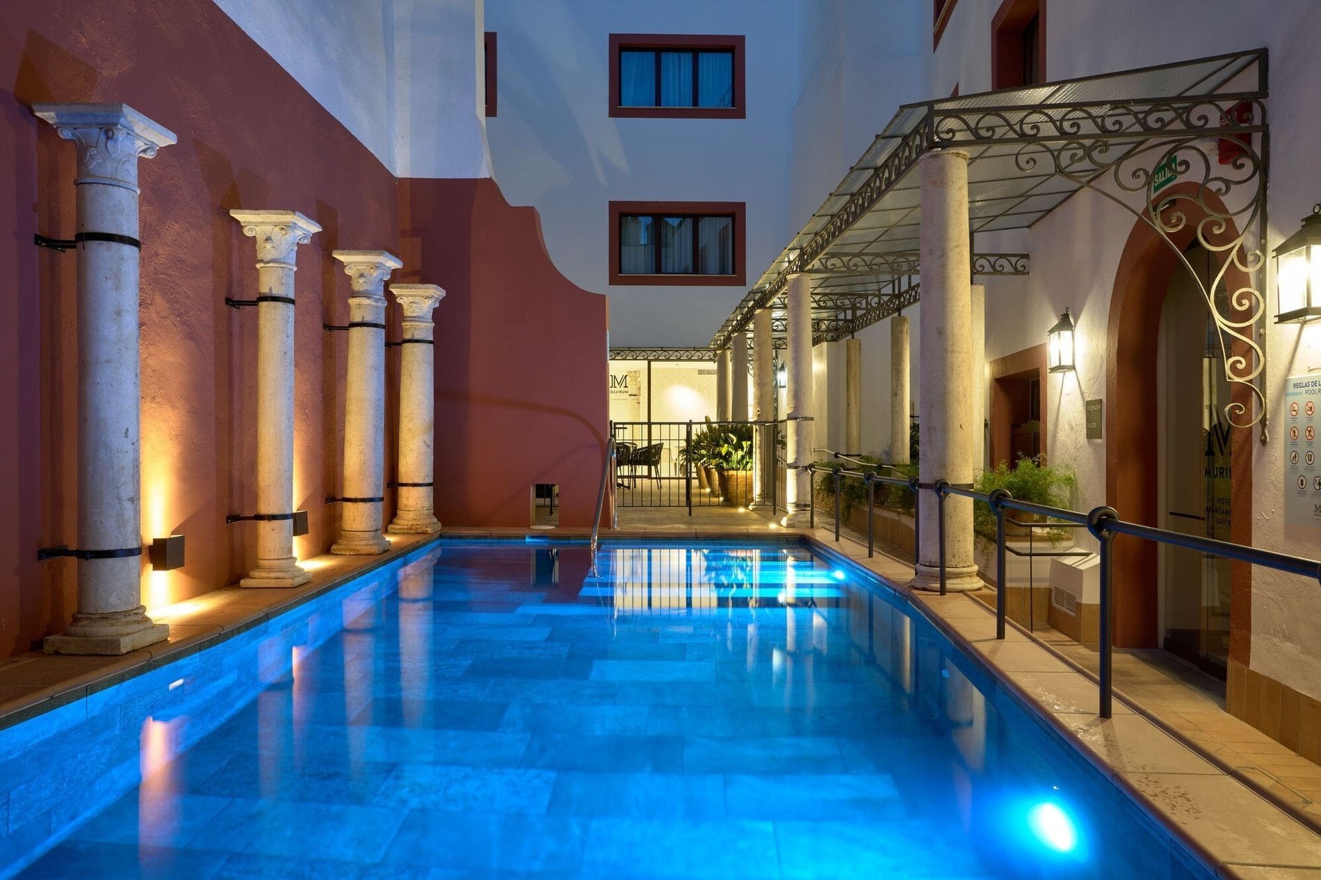 Piscina en Patio de Hotel Murillo Reinoso al anochecer
