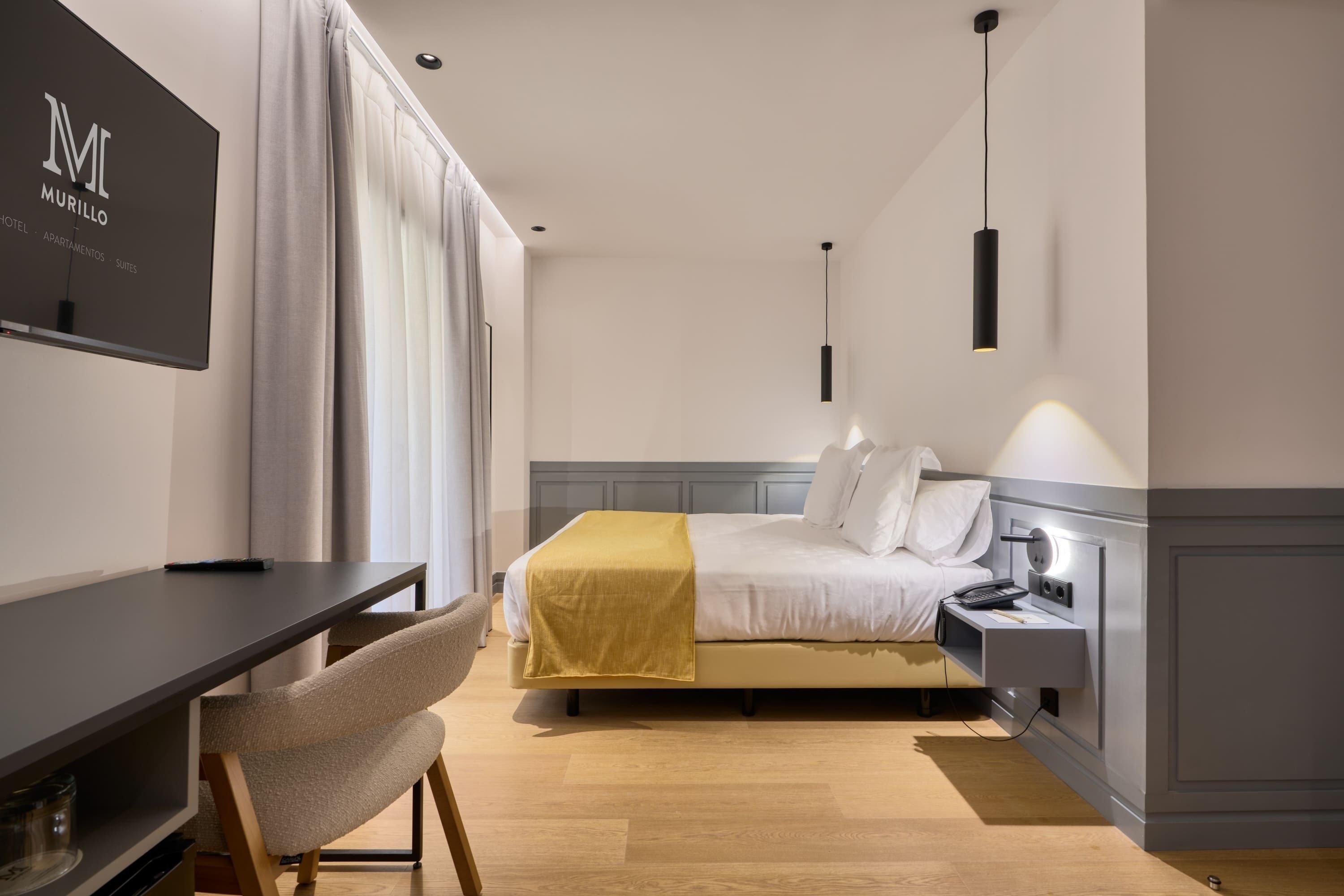 una habitación de hotel con una cama y una televisión de murillo