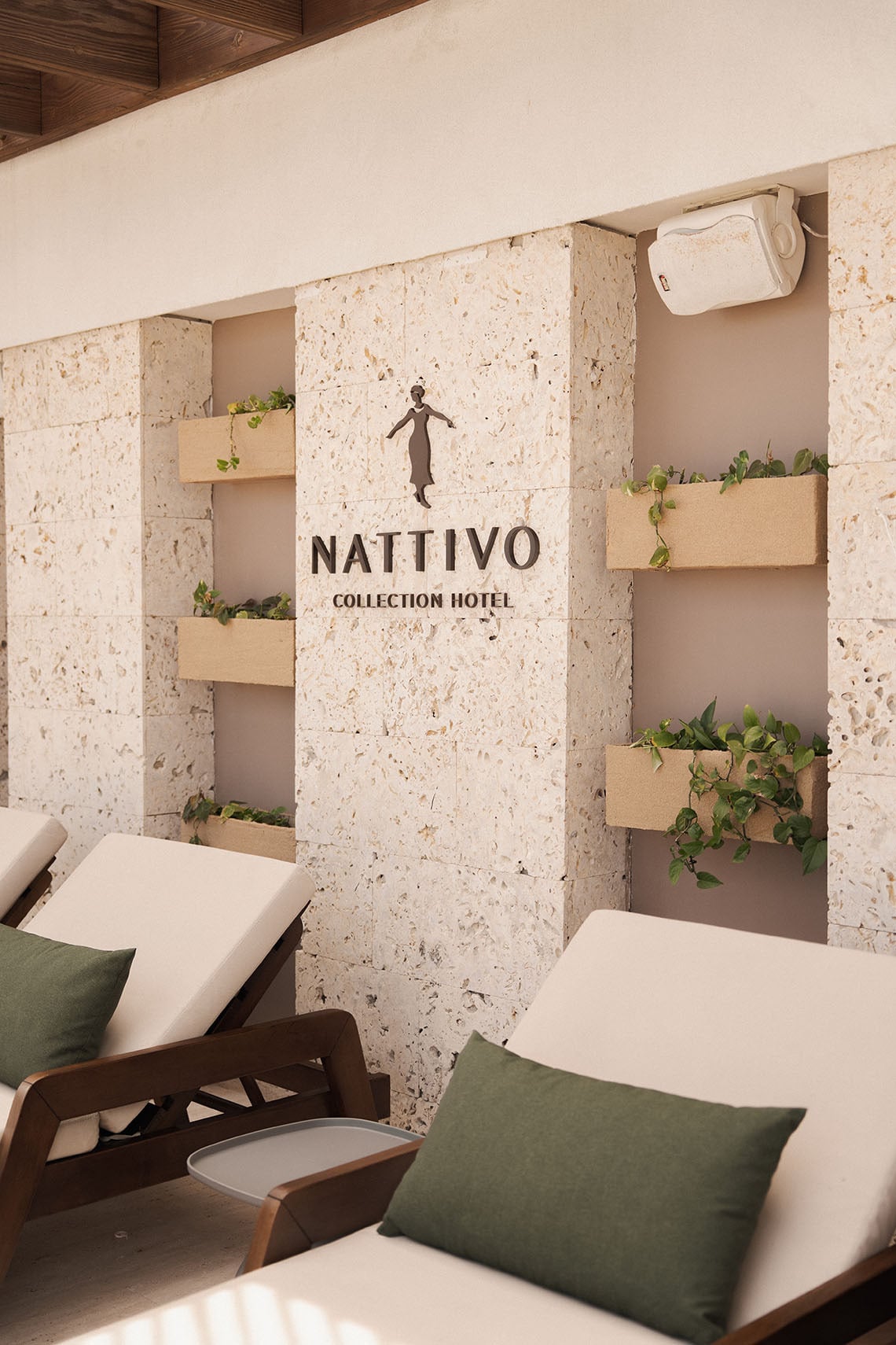 Toallas de lujo con logo 'NATIVO COLLECTION HOTEL' junto a un lavabo de piedra natural. Nattivo Collection Hotel