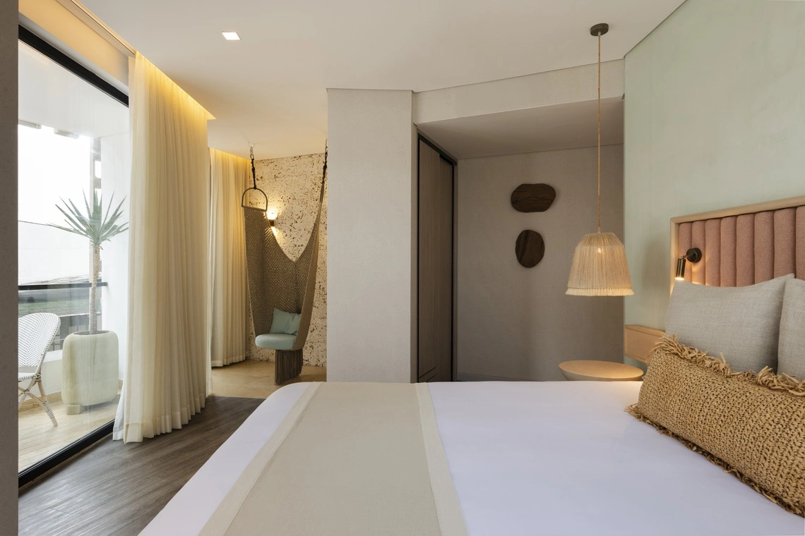 Quarto de hotel moderno com rede, varanda e cama confortável. Nattivo Collection Hotel