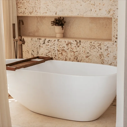 Bañera exenta blanca con ducha y toallero de madera, perfecta para tu estancia Nattivo Collection Hotel.