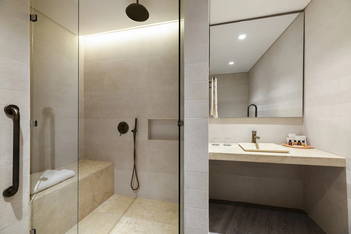 Banheiro moderno com ducha e pia, oferecendo conforto e estilo em Nattivo Collection Hotel.