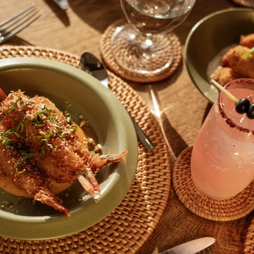 Nattivo Collection Hotel: camarones empanizados con un cóctel rosa y aperitivos en un entorno rústico.