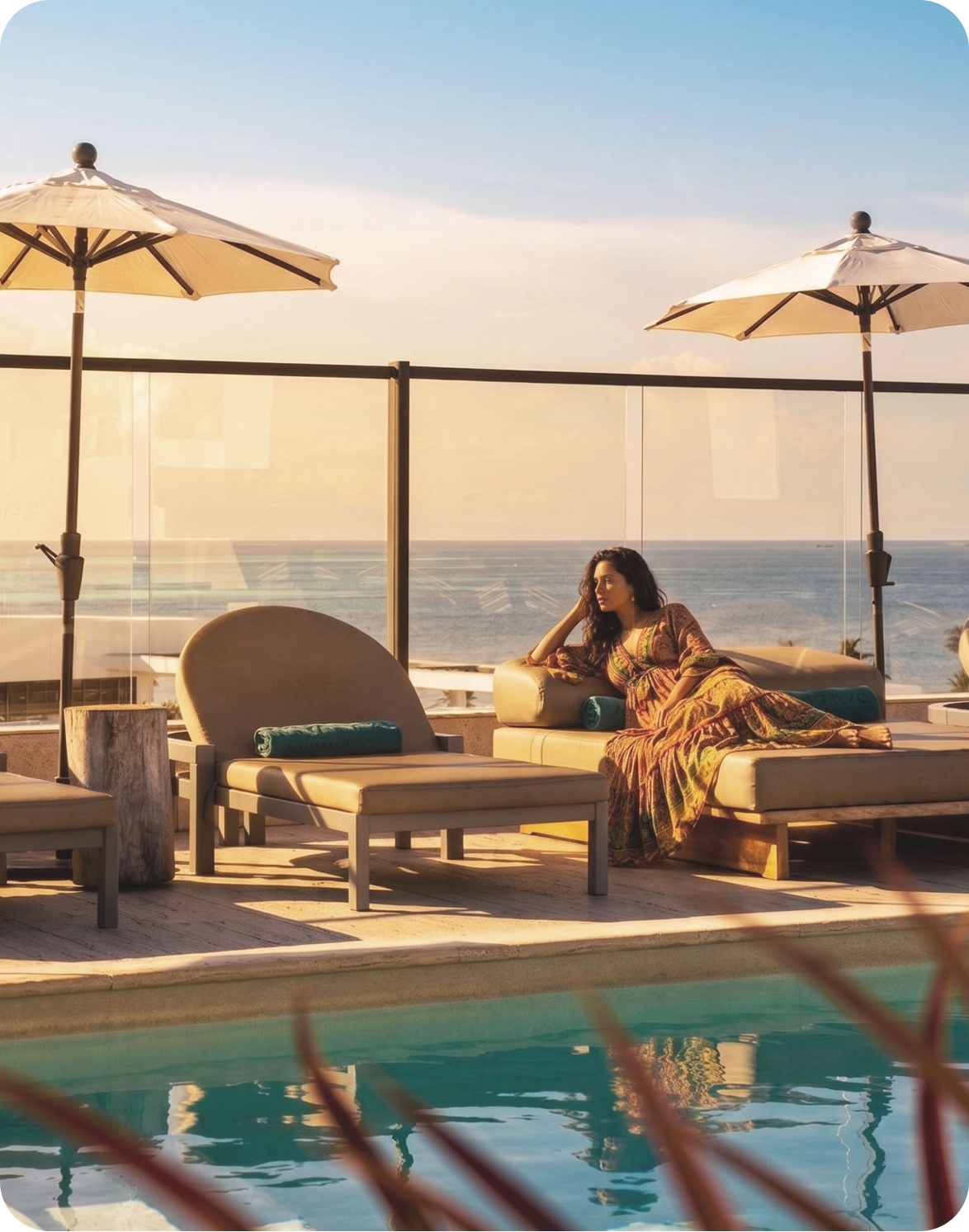 Mulher relaxa em espreguiçadeira ao lado da piscina com vista para o mar, Nattivo Collection Hotel