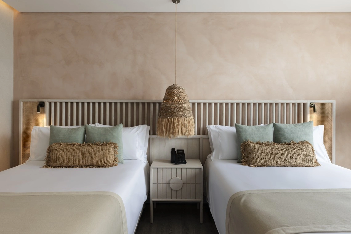 Quarto de hotel com duas camas, travesseiros texturizados e iluminação de ambiente, ideal paraNattivo Collection Hotel.