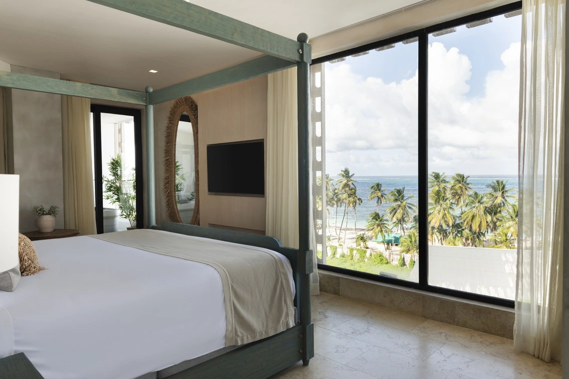 Quarto de luxo com Nattivo Collection Hotel vista para o mar e coqueiros.