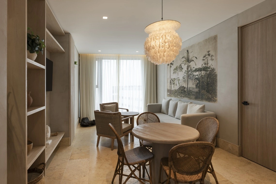 Sala de estar e jantar elegante com móveis de vime e tapeçaria botânica. Nattivo Collection Hotel