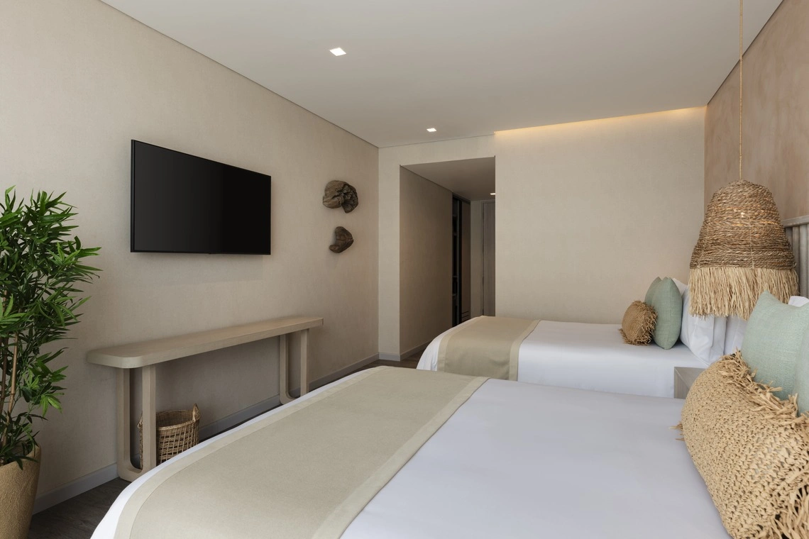 Quarto de hotel com duas camas, TV e lustre de palha. Nattivo Collection Hotel.
