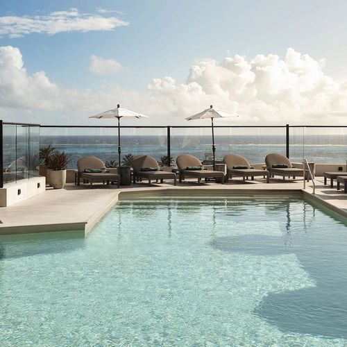 Piscina en la azotea con tumbonas y vista al mar. Nattivo Collection Hotel