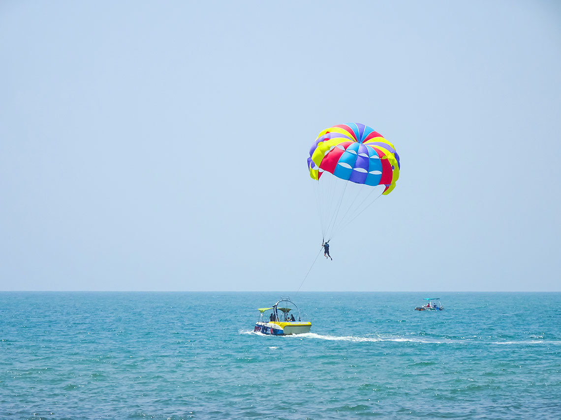 Parasailing sobre as águas azuis em Nattivo Collection Hotel com vista para a praia.