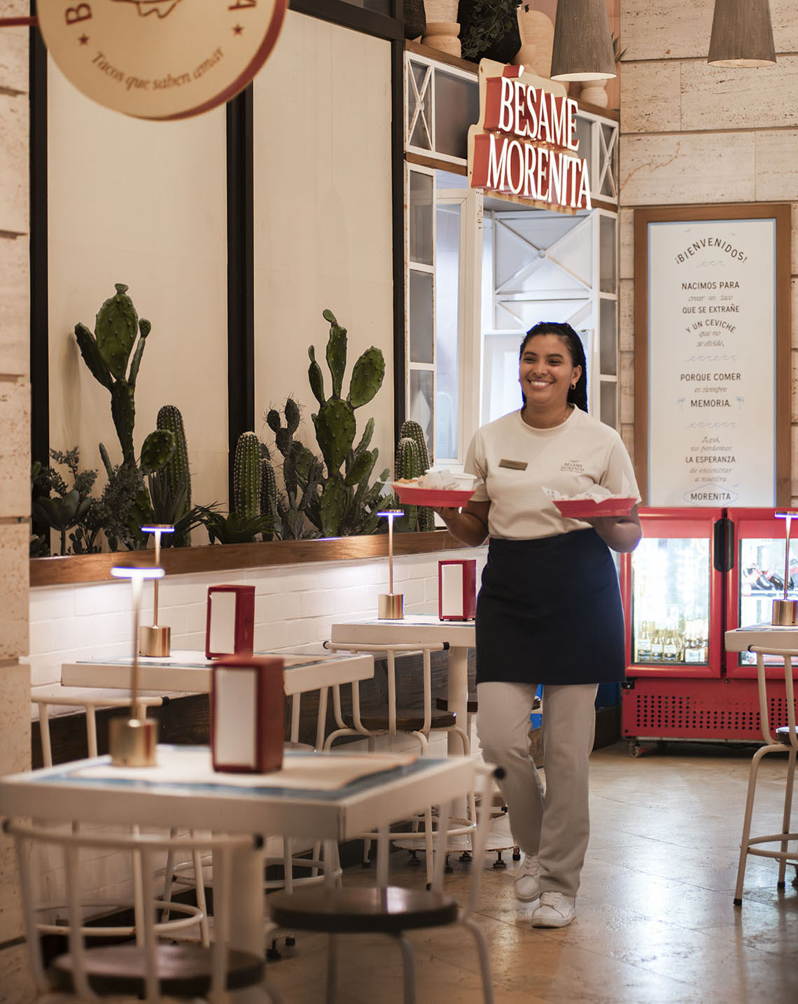 Garçonete em restaurante mexicano, com mesa e cactos Nattivo Collection Hotel.