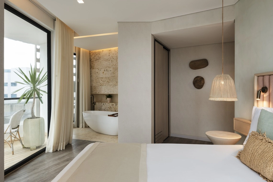 Quarto de hotelNattivo Collection Hotel com banheira exposta, varanda e decoração natural.