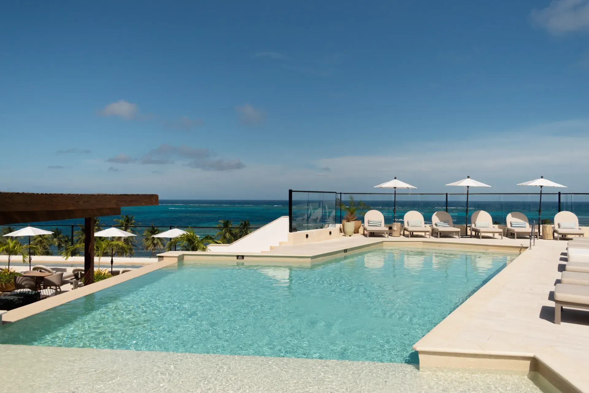 Piscina en azotea con vista al mar y tumbonas, ideal para Nattivo Collection Hotel.