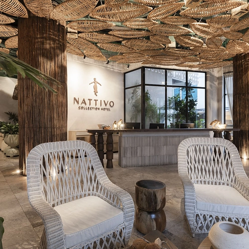 Lobby del hotel Nativo, con sillas de mimbre blancas y decoración de ratán. Nattivo Collection Hotel