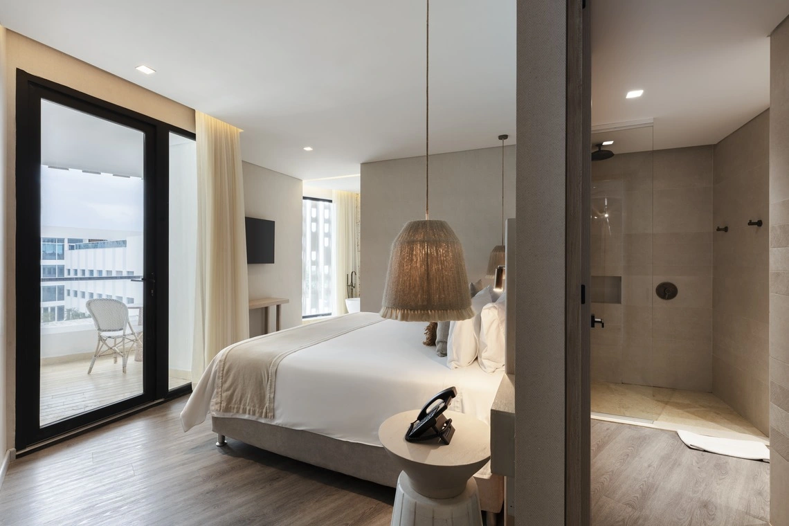 Quarto de hotel moderno com varanda, Nattivo Collection Hotel e banheiro privativo com chuveiro.