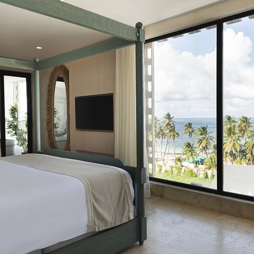 Suite de Nattivo Collection Hotel con vista al mar y palmeras.