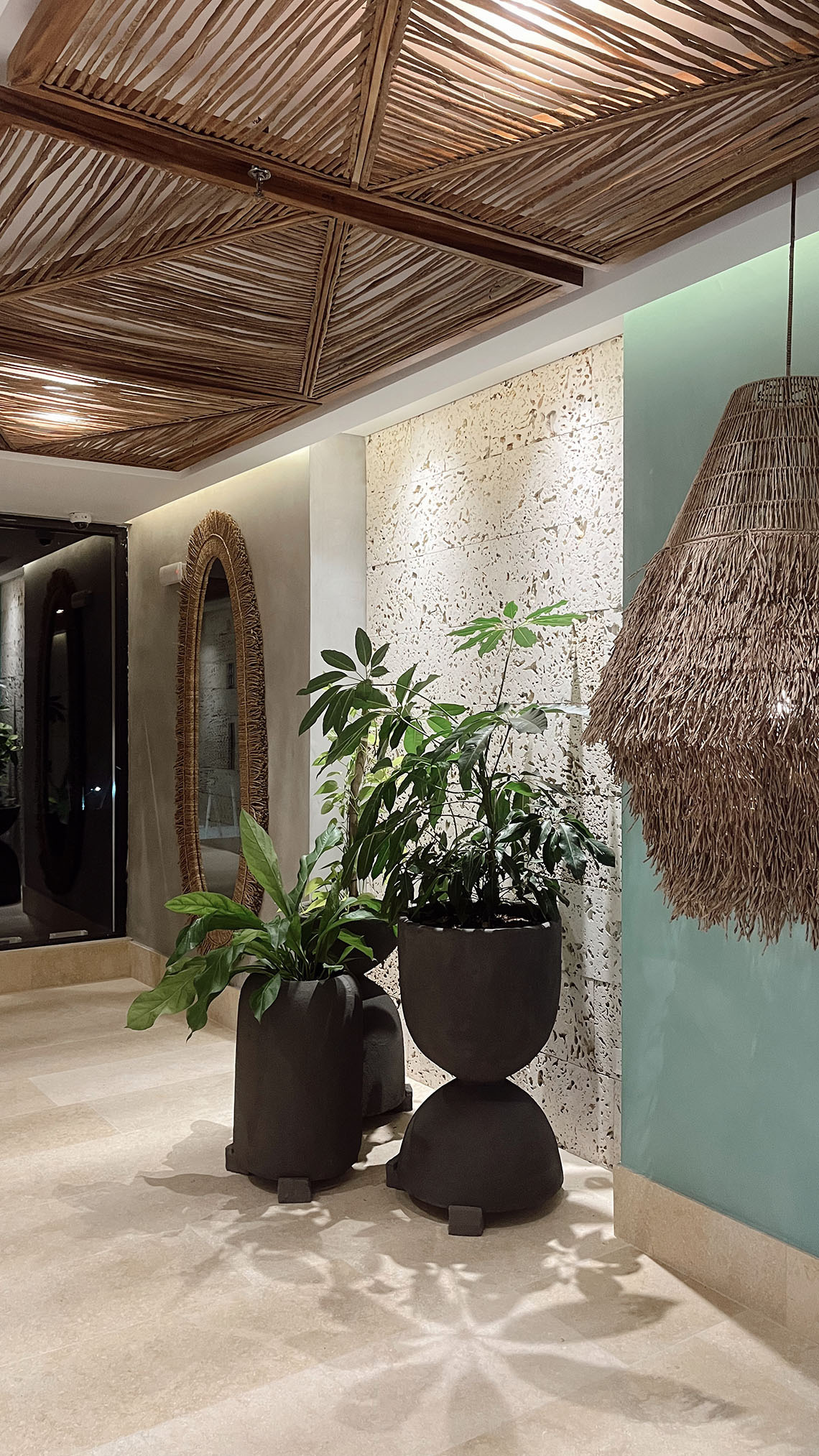 Ambiente acolhedor de restaurante de hotel com mesas arrumadas e plantas penduradas Nattivo Collection Hotel.