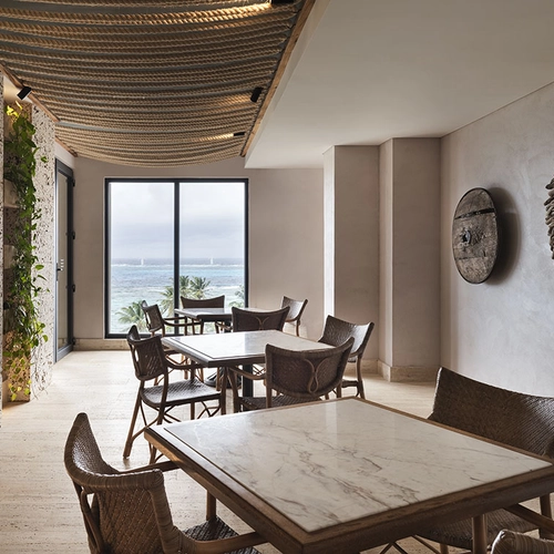 Nattivo Collection Hotel: elegante comedor con vistas al mar Caribe, materiales naturales y luz cálida.