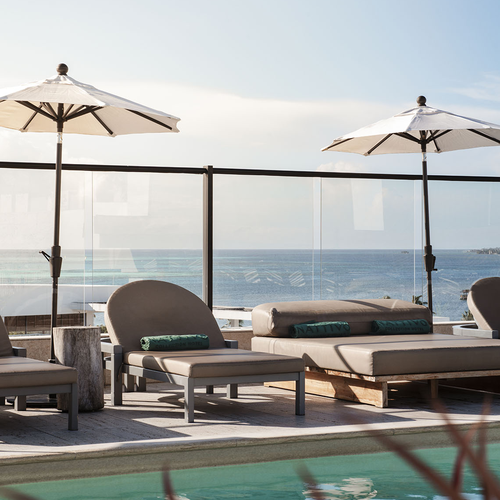 Tumbonas junto a la piscina con vistas al mar, perfectas para Nattivo Collection Hotel.
