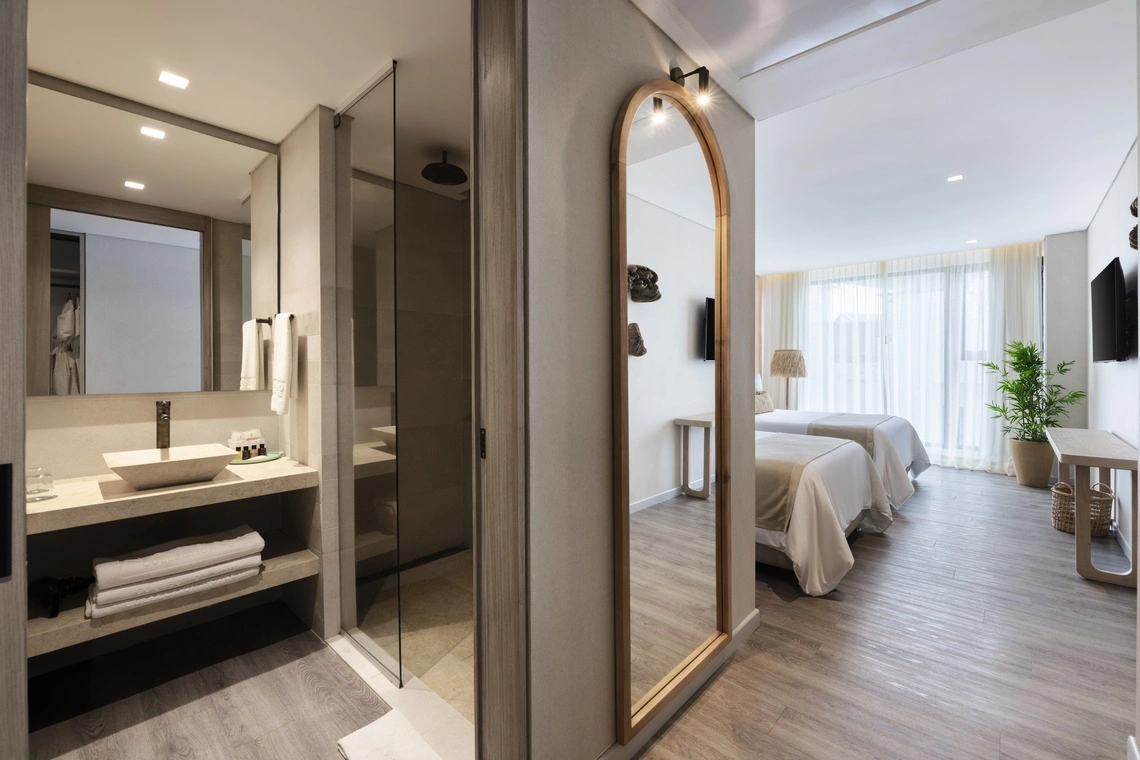 Quarto de hotel moderno com banheiro e camas confortáveis. Descubra o @Nattivo Collection Hotel do seu próximo refúgio.