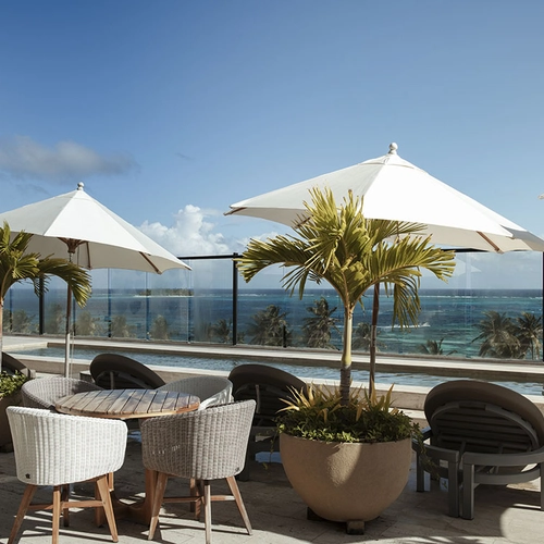 Terraza con vista al mar, sillas, mesas y sombrillas. Nattivo Collection Hotel.