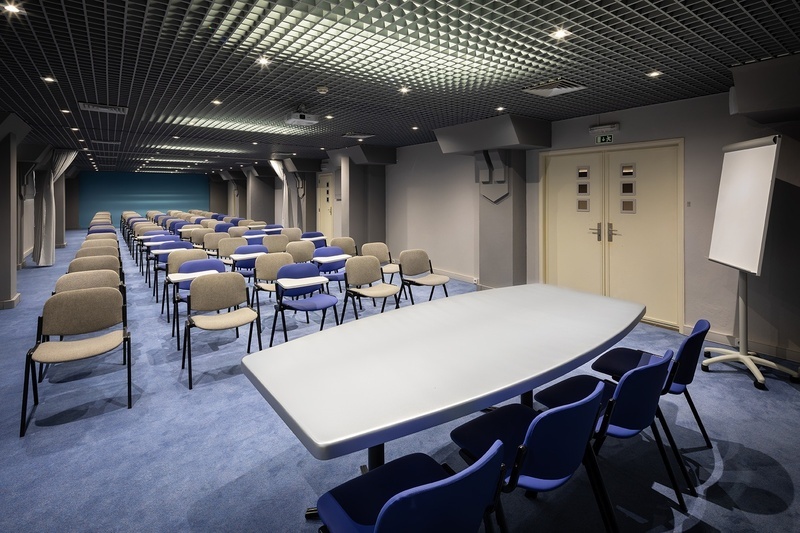 a conference room with blue chairs and a white board