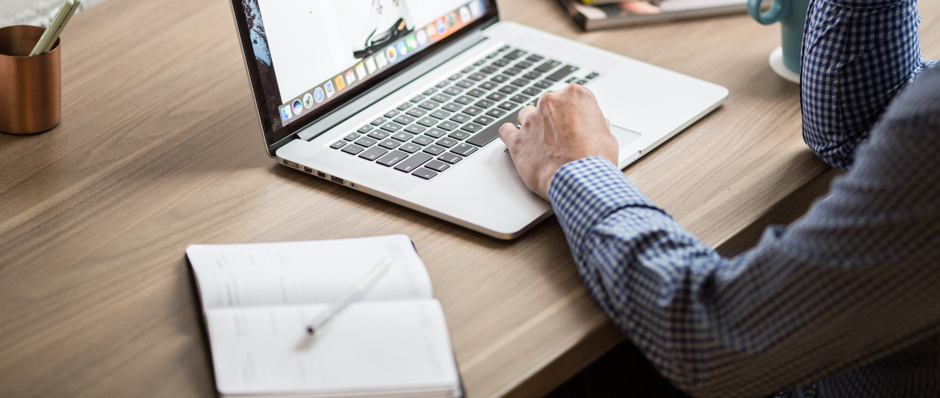 um homem está digitando em um laptop em uma mesa