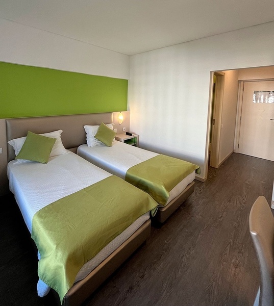 um quarto de hotel com cama e sofá verdes