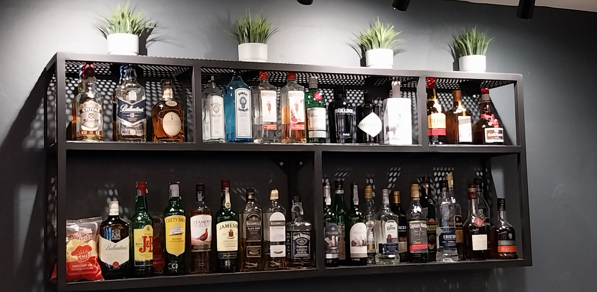 uma prateleira cheia de garrafas de licor e chips