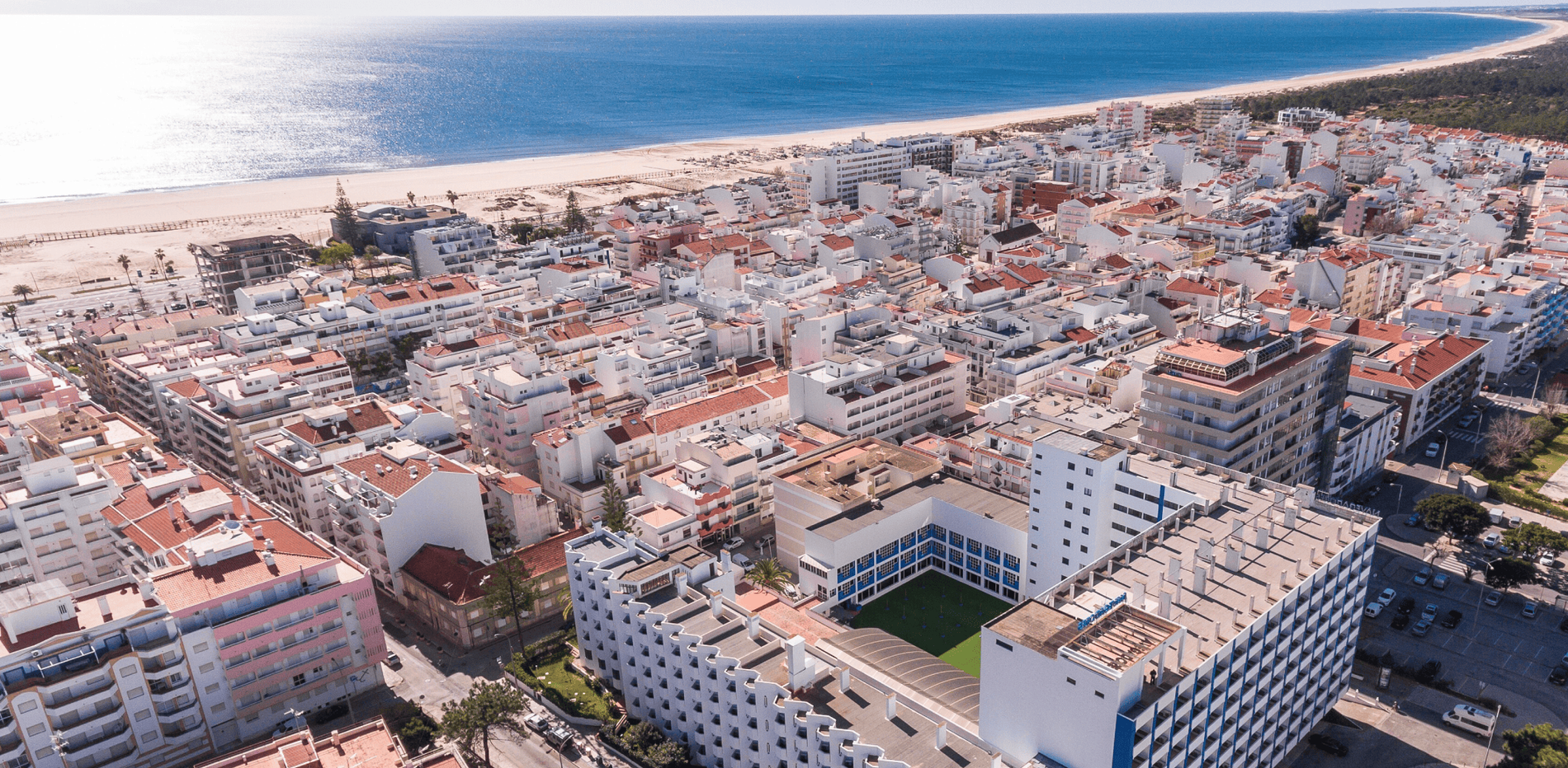 une vue aérienne d' une ville avec un grand bâtiment bleu et blanc au milieu
