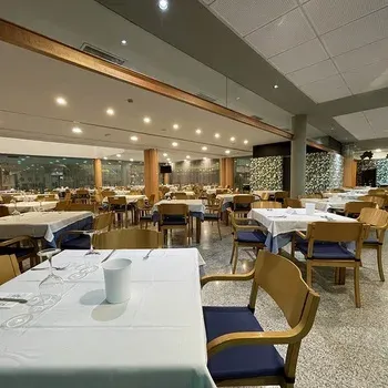On Hotels: Neptuno dining room with set tables and wooden chairs.