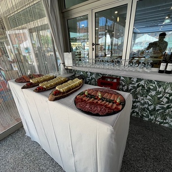 uma mesa cheia de pratos de comida e garrafas de vinho