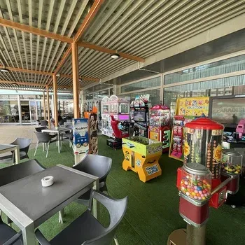 Game room and terrace at Hoteles Neptuno, featuring arcade machines.