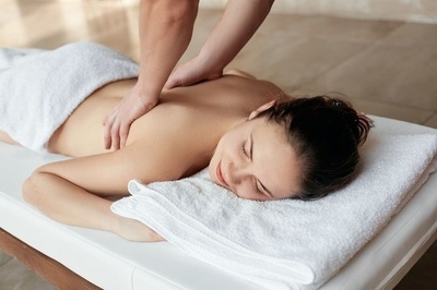 a woman is laying on a bed getting a massage