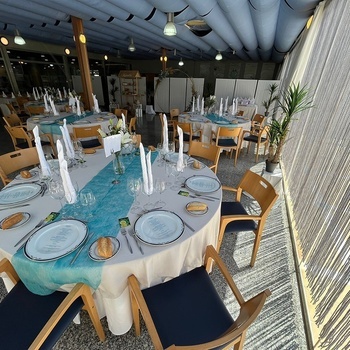 une table avec une nappe bleue et des assiettes blanches