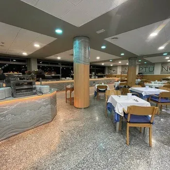 Hotel Neptuno dining room with set tables and buffet.