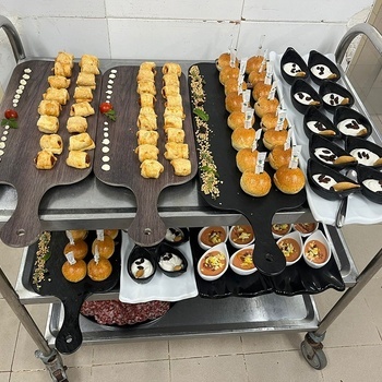 several trays of food on a cart with one that says ' a ' on it