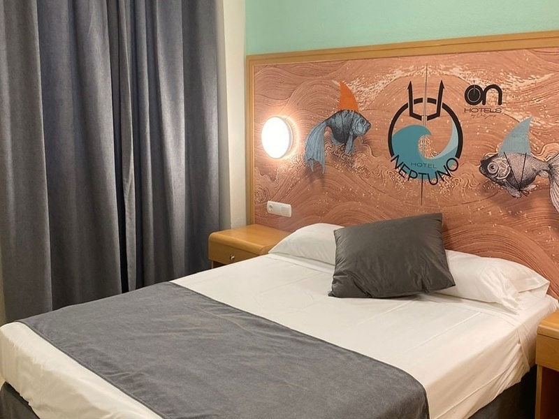 a bed with a headboard that says hotel neptune on it