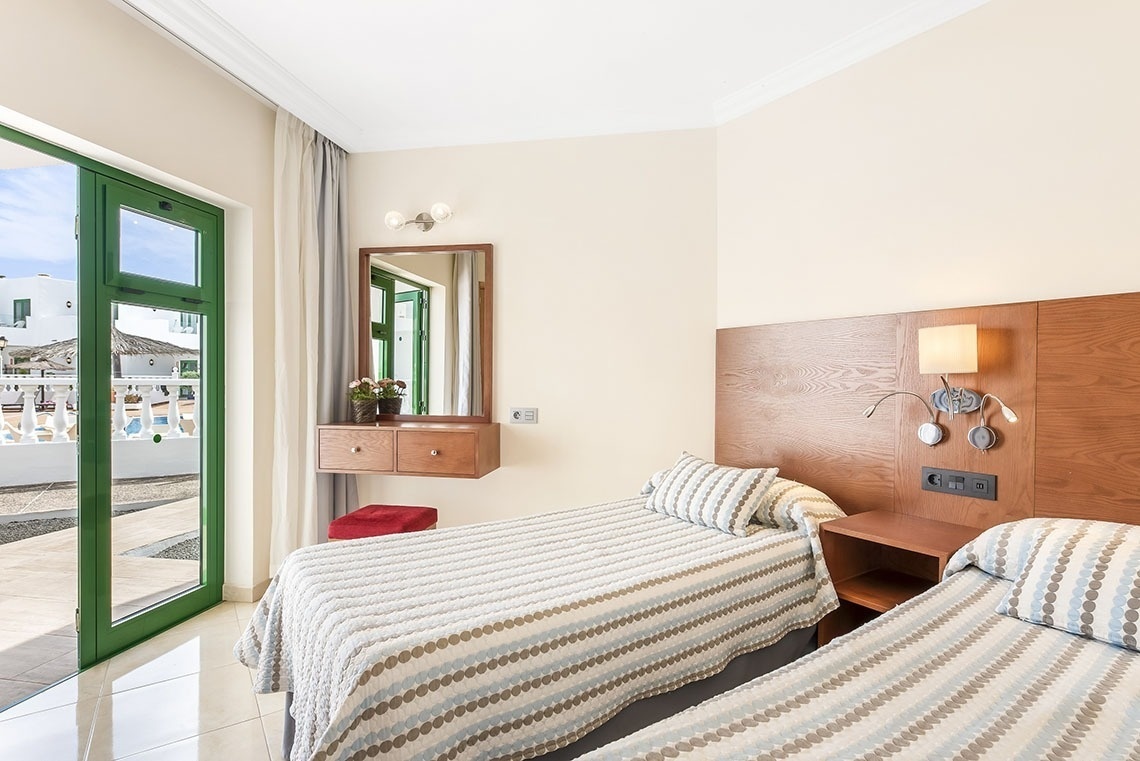 ein Schlafzimmer mit zwei Betten und einem Spiegel